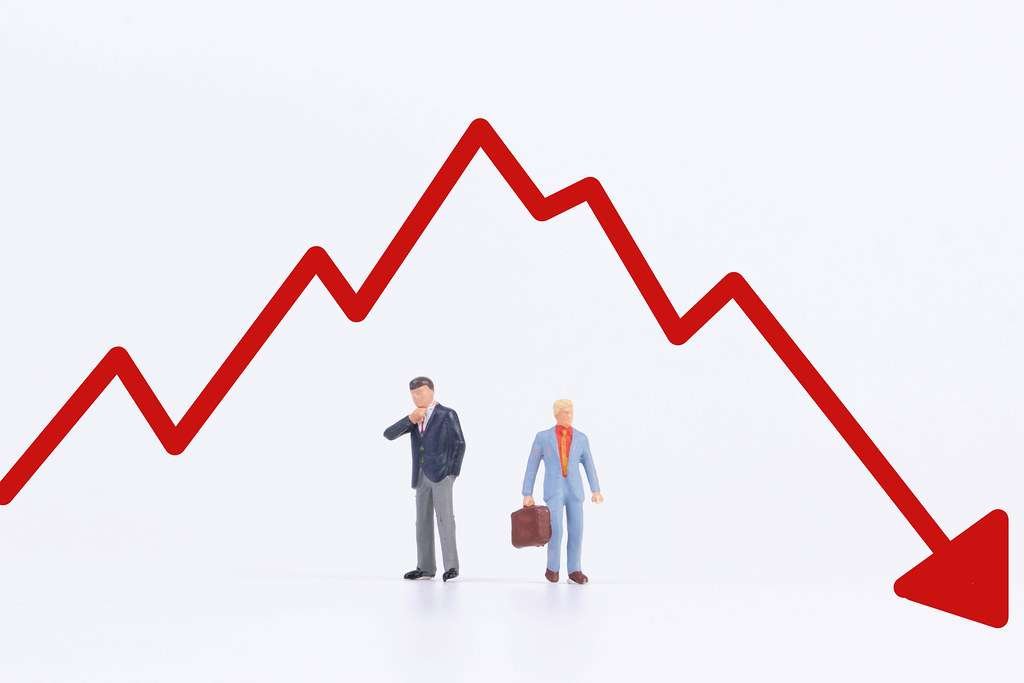 Two animated man under the graph of stock market going down 