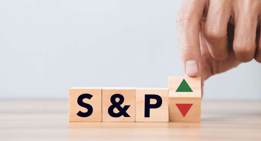 S&P written on cube and place on table , a person turning on of the cube 