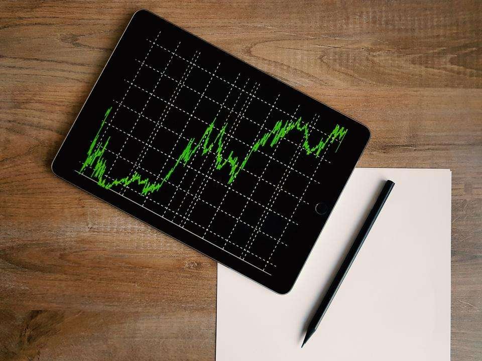 trading stock graph on tablet and a paper, pen with tablet place on wooden table